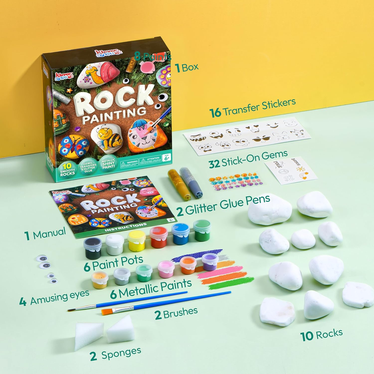 Rock painting kit with various supplies on a green surface