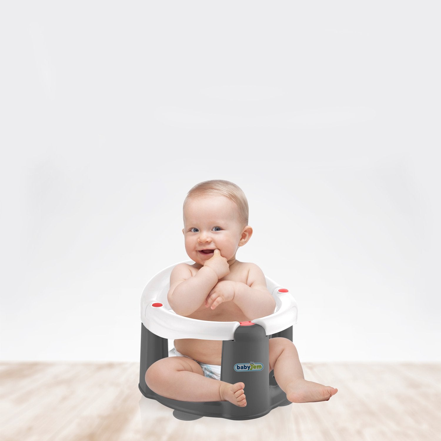 Baby sitting in a gray and white baby seat 