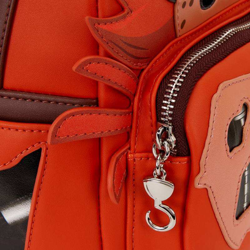 Close-up of a red handbag with decorative elements and a silver zipper pull.