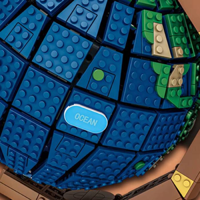Close-up of a blue and green toy with 'OCEAN' label, resembling a LEGO-like structure.