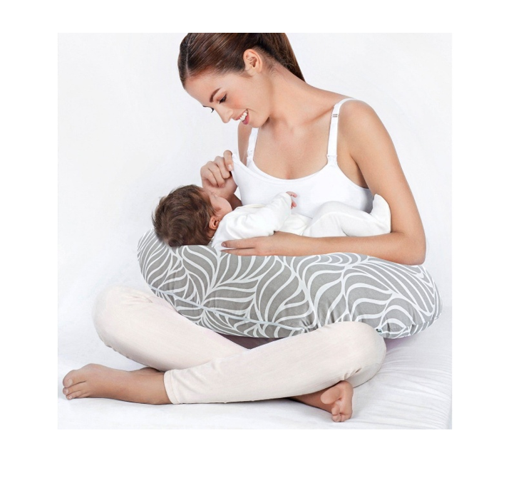 Woman using a nursing pillow to breastfeed a baby 