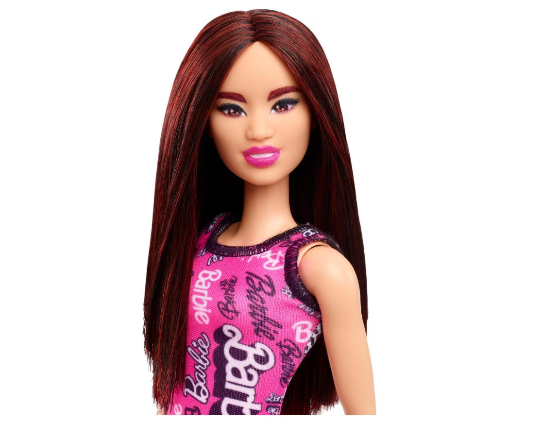 دمية باربي فاشون من ماتيل بشعر أسود مستقيم، ترتدي فستانًا ورديًا قابلًا للإزالة وحذاءً مطبوعًا عليه شعار 